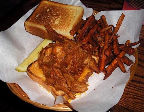 Pulled pork with Carolina-style sauce with Cheddar cheese on Texas toast with red onion relish and sweet potato fries